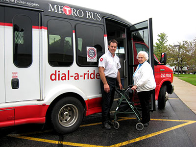 Photo of a transit bus with driver and passenger standing outside it